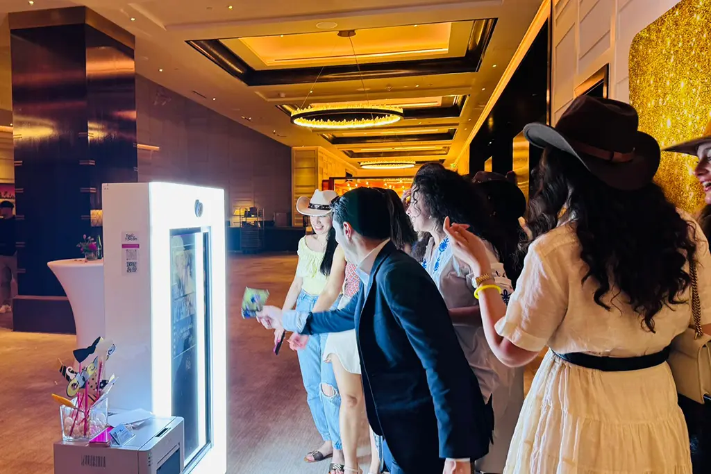 Friends celebrating with instant photo strips at a PartyBooth rental